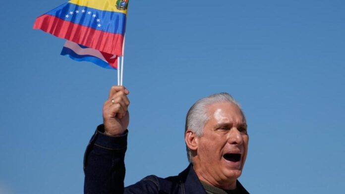 Presidente de Cuba sosteniendo la bandera nacional durante un acto oficial